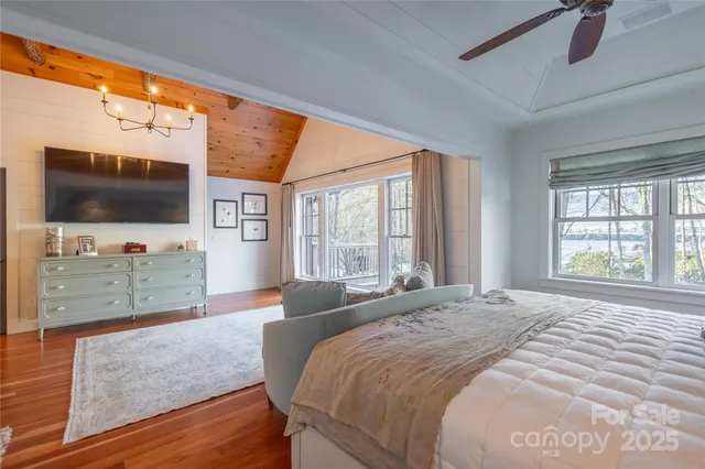 a spacious bedroom with a large bed and a flat screen tv