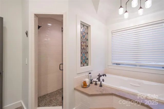 a bathroom with a tub sink and mirror