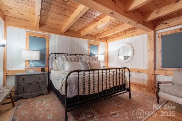 a bedroom with a bed a dresser next to a window