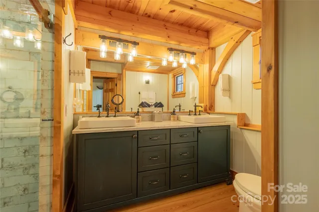 a bathroom with a granite countertop sink a toilet and shower