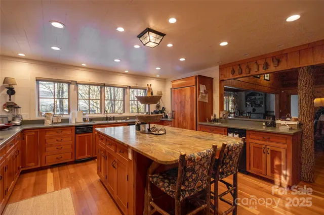 a kitchen with stainless steel appliances granite countertop table chairs sink and cabinets