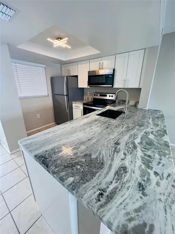 a kitchen with stainless steel appliances granite countertop a sink stove and microwave