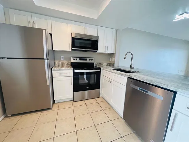 a kitchen with stainless steel appliances granite countertop a refrigerator sink and microwave