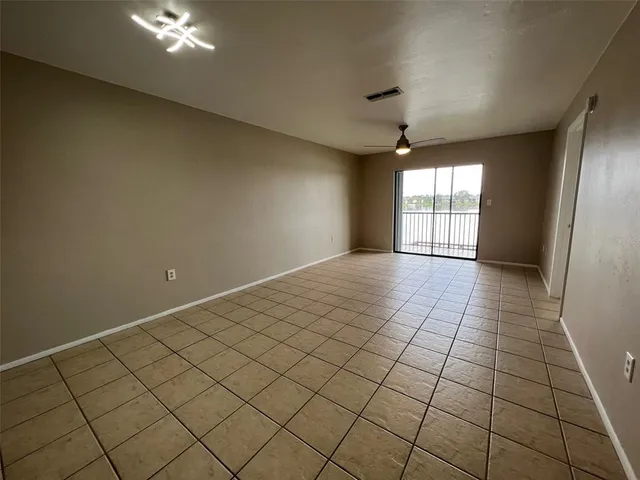 an empty room with windows and fan