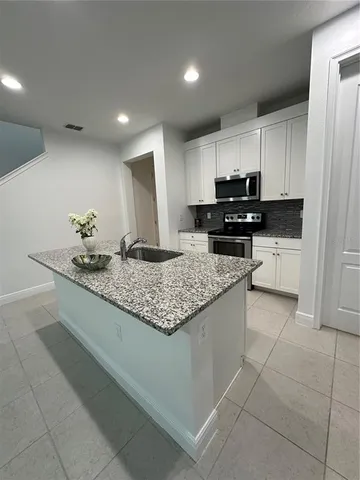 a view of a refrigerator in kitchen and an empty room