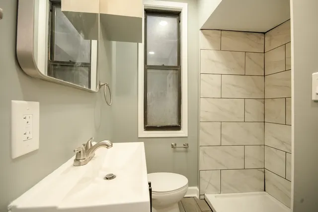 a bathroom with a sink a toilet and shower