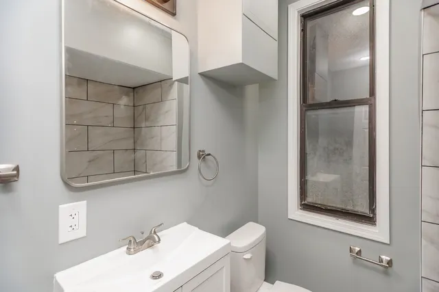 a bathroom with a sink mirror and toilet