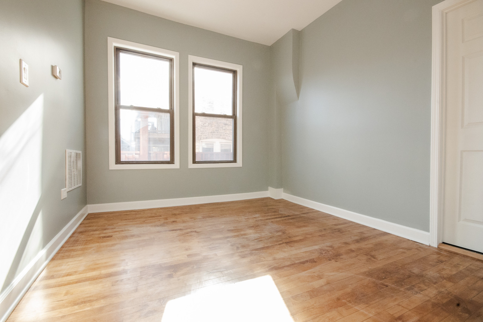 925 South Laflin Street, Unit 2R Chicago, IL 60607 - Photo 4 of 29 an empty room with wooden floor and windows