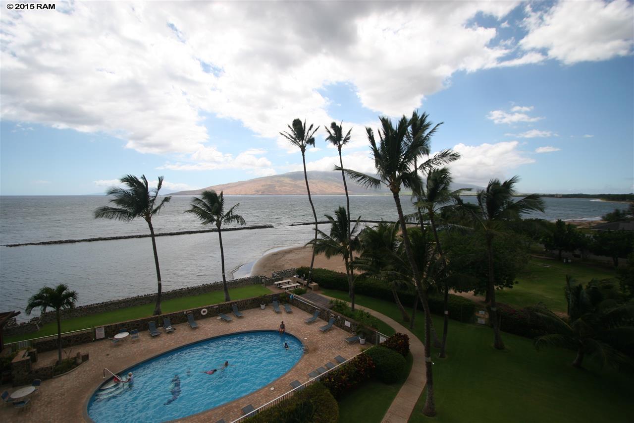 a view of a swimming pool with a yard and sitting area