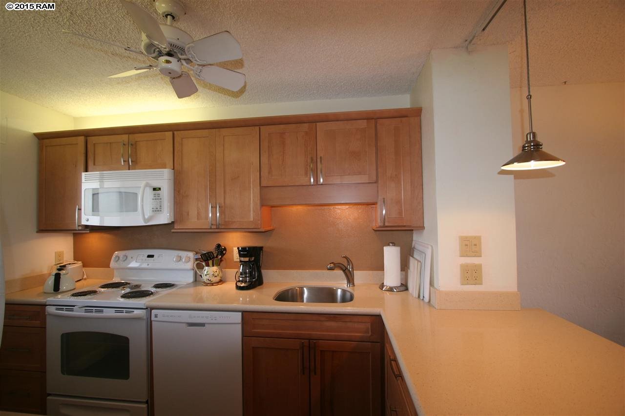 760 South Kihei Road, Unit 507 Kihei, HI 96753 - Photo 3 of 15 a kitchen with a stove a sink and a refrigerator