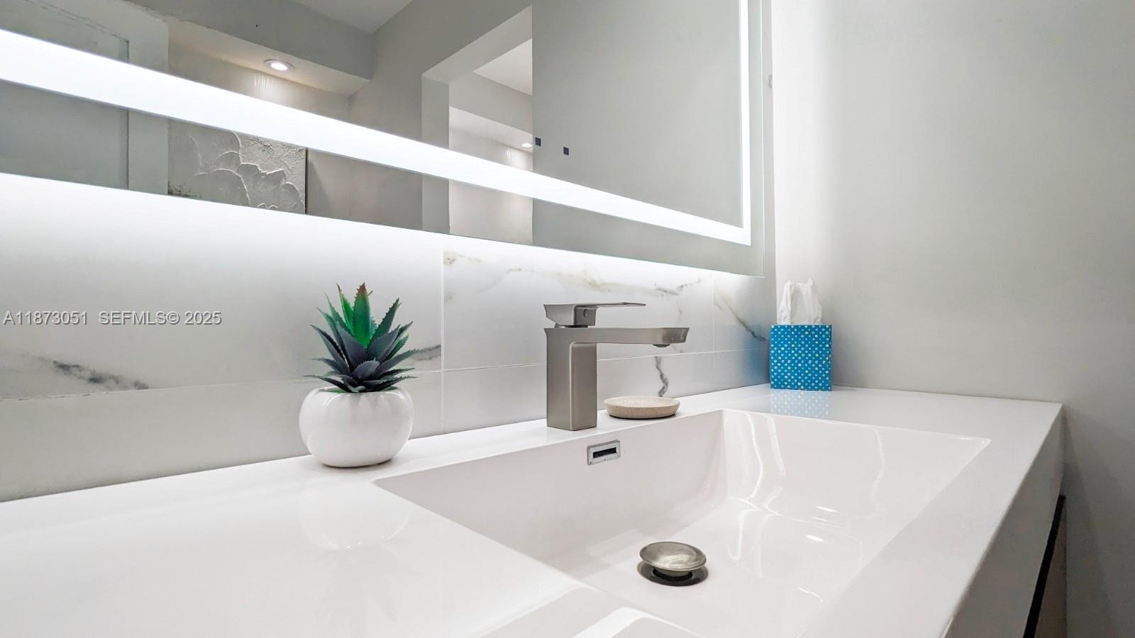 4027 Pierce Street Hollywood, FL 33021 - Photo 13 of 22 a bathroom with a sink and a mirror