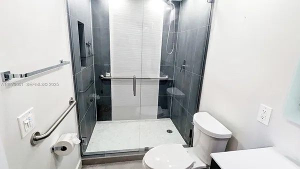 a bathroom with a toilet and a shower