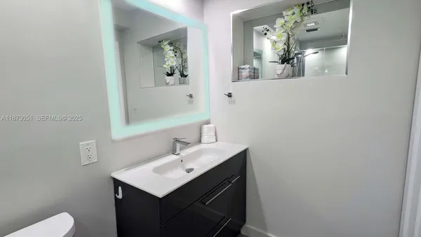 a bathroom with a sink vanity and mirror