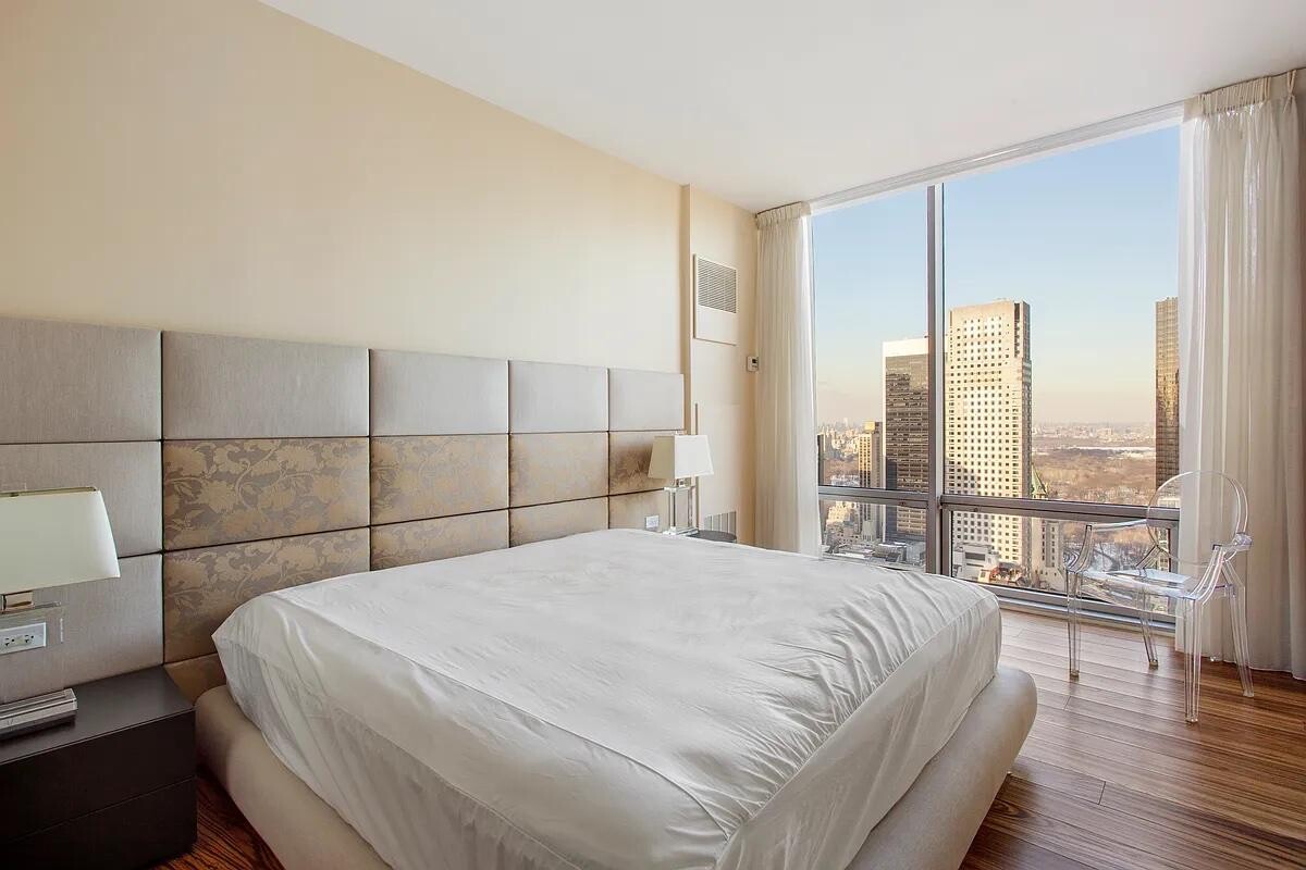 641 5th Avenue, Unit 38B Manhattan, NY 10022 - Photo 5 of 8 a bedroom with a large bed and a large window