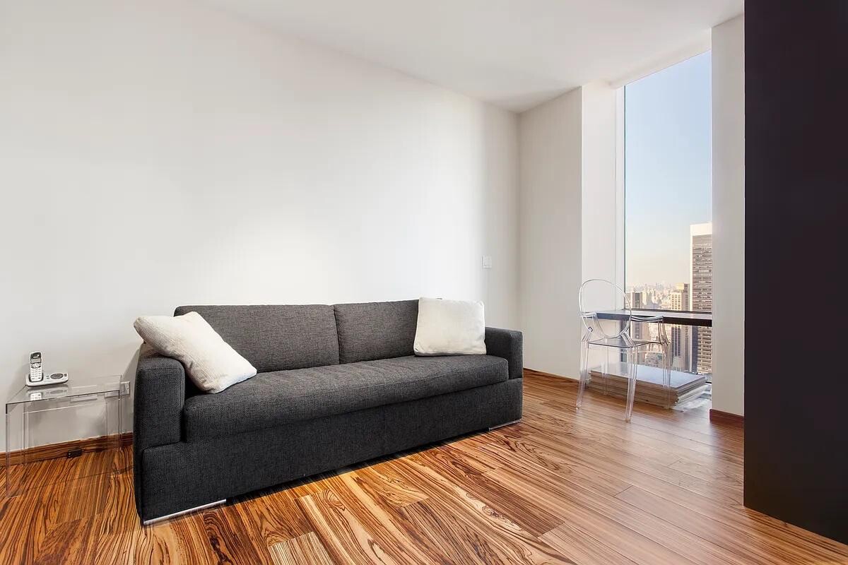 641 5th Avenue, Unit 38B Manhattan, NY 10022 - Photo 6 of 8 a living room with furniture and a wooden floor