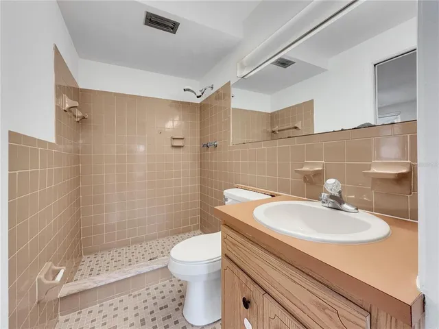 a bathroom with a sink toilet a mirror and shower