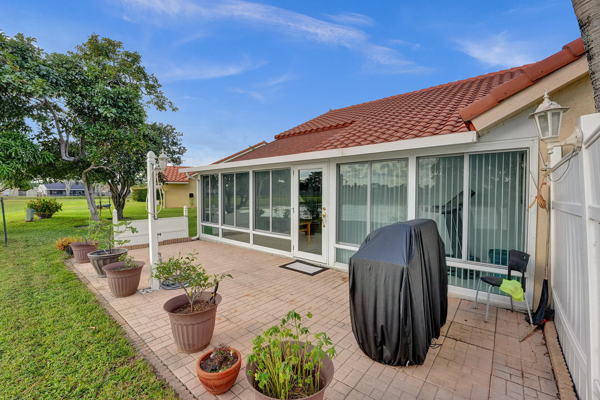 5447 Helene Circle Boynton Beach, FL 33472 - Photo 5 of 40 a house with potted plants in front of it