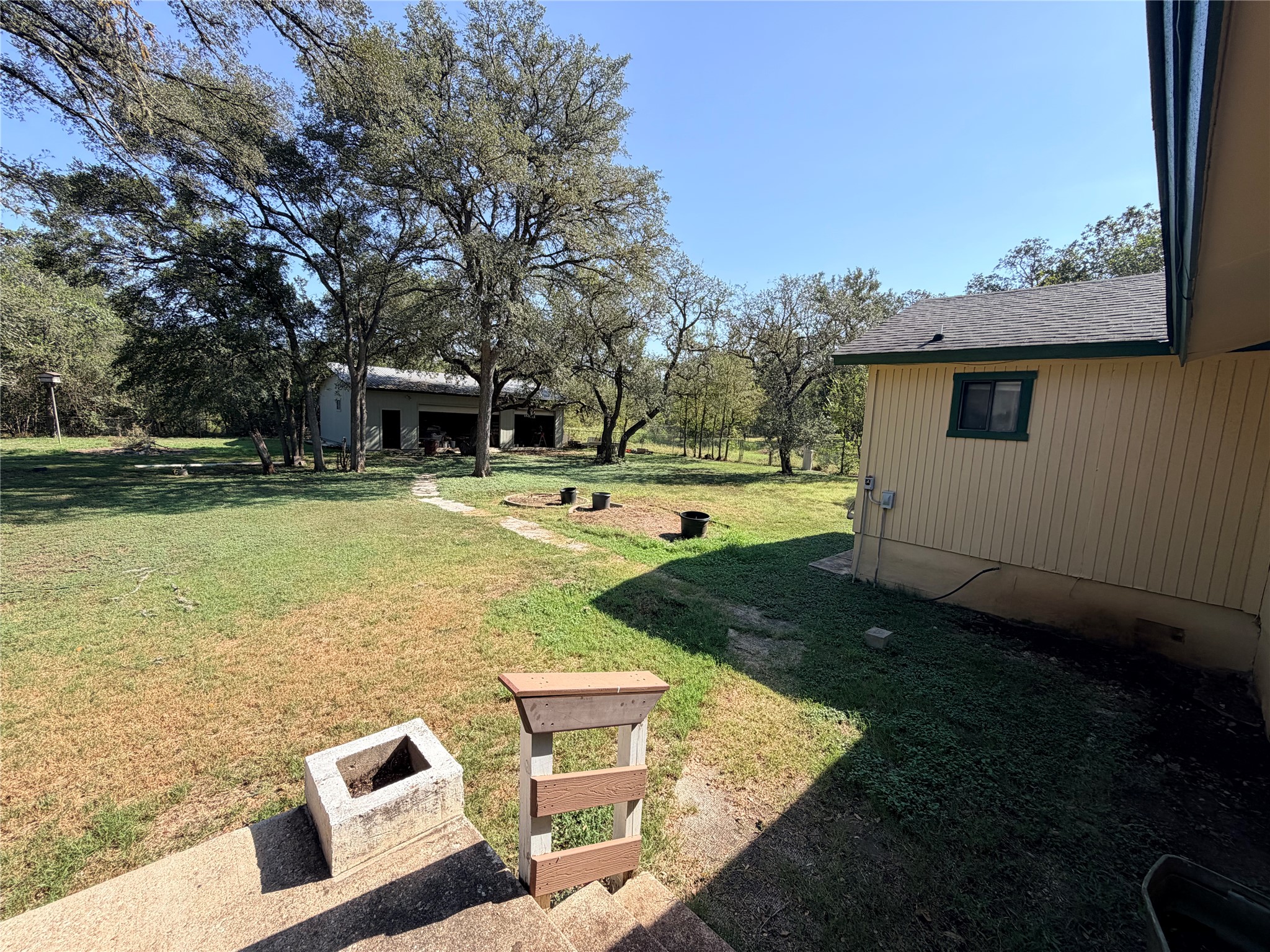 2800 Robin Road Manchaca, TX 78652 - Photo 24 of 28 Mature trees shade a spacious grassy yard featuring a detached outbuilding.