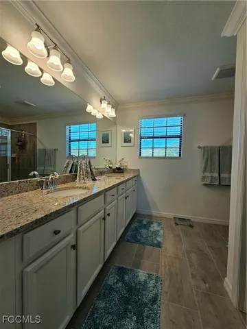 a spacious bathroom with a granite countertop sink a mirror and a shower
