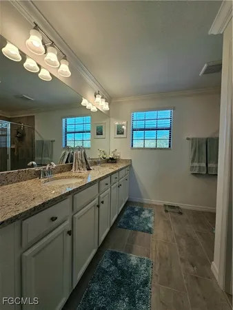 a spacious bathroom with a granite countertop sink a mirror and a shower