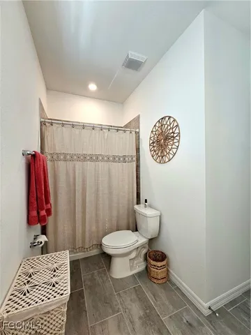 a bathroom with a toilet and a shower