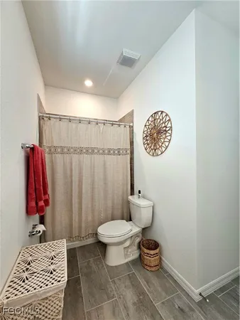 a bathroom with a toilet and a shower
