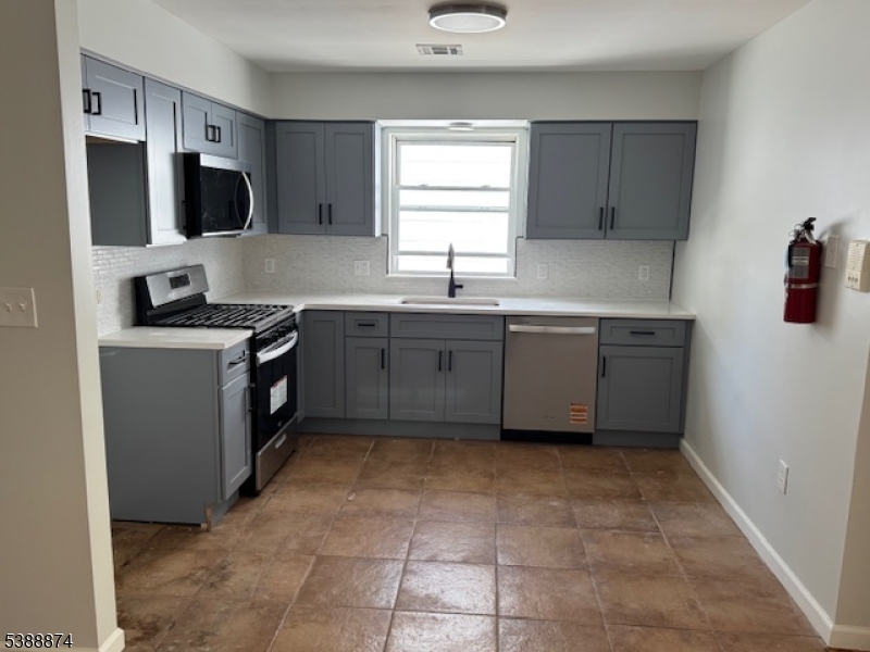 74 Kenmore Avenue, Unit 2 Newark, NJ 07106 - Photo 2 of 6 a kitchen with stainless steel appliances granite countertop a sink stove and refrigerator
