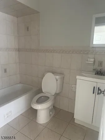 a white toilet sitting next to a bath tub and a sink