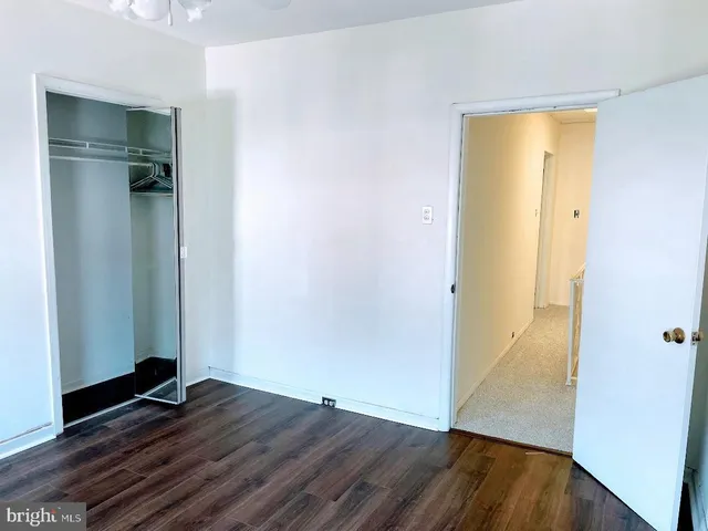an empty room with wooden floor and closet