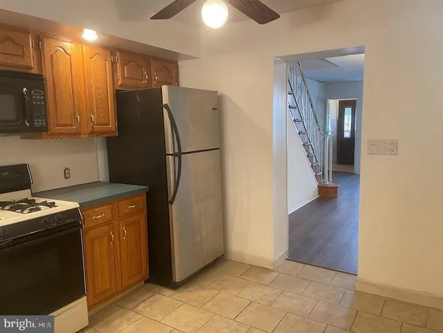 a kitchen with a refrigerator a stove top oven and cabinets