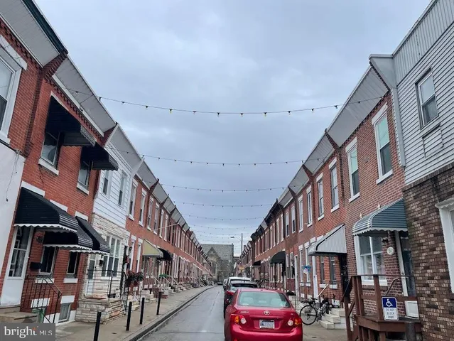 a city street lined with buildings and cars parked on the road