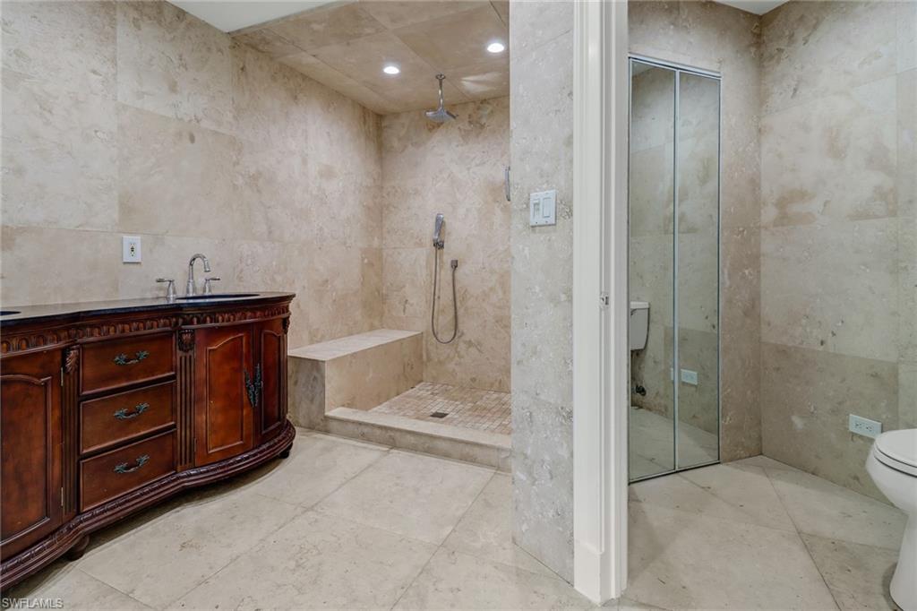 4540 Pine Ridge Road Naples, FL 34119 - Photo 19 of 30 a bathroom with a shower sink and mirror