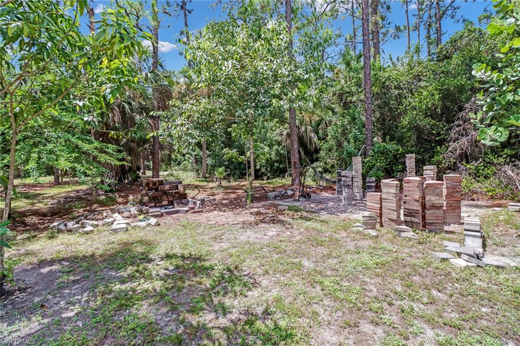 4540 Pine Ridge Road Naples, FL 34119 - Photo 29 of 30 a view of backyard with a bench and trees
