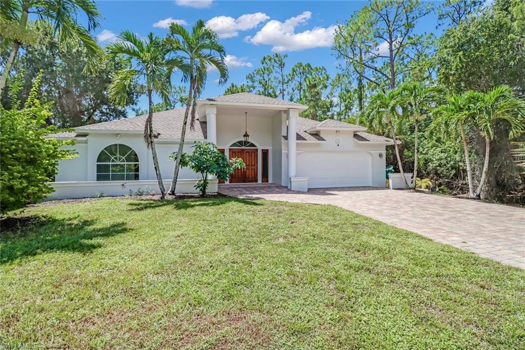 4540 Pine Ridge Road Naples, FL 34119 - Photo 3 of 30 a front view of a house with garden