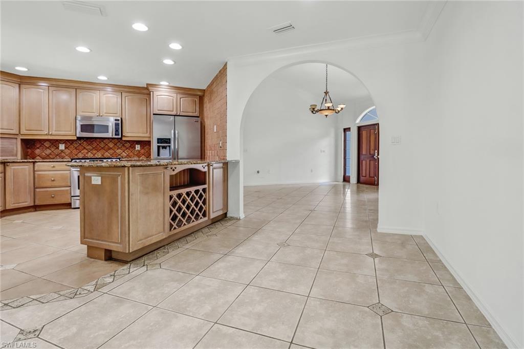 4540 Pine Ridge Road Naples, FL 34119 - Photo 8 of 30 a kitchen with stainless steel appliances granite countertop a stove a sink and a refrigerator