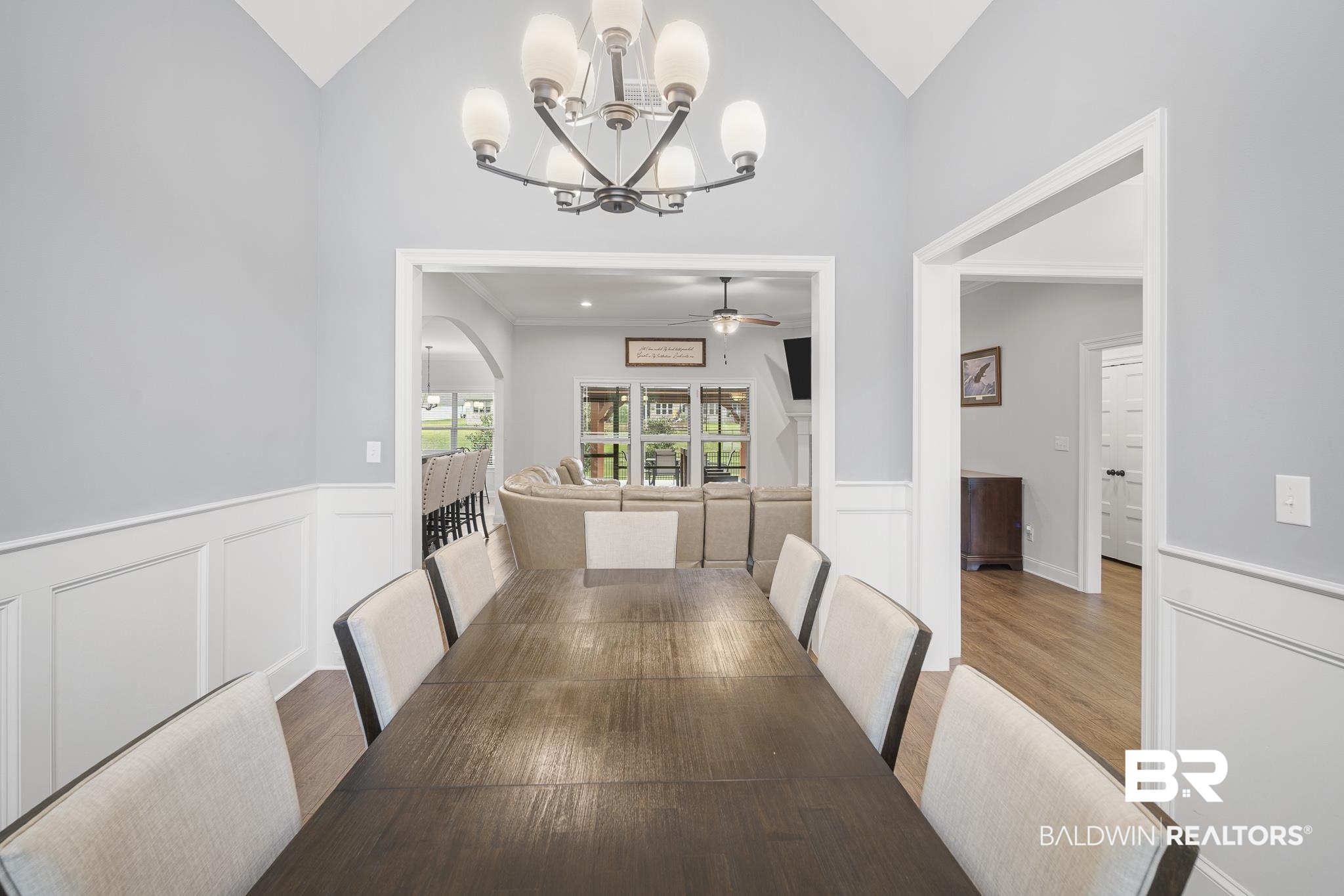 12672 Squirrel Drive Daphne, AL 36527 - Photo 6 of 49 Dining space featuring vaulted ceilings, chair rail molding, wainscoting, and wood-finish flooring