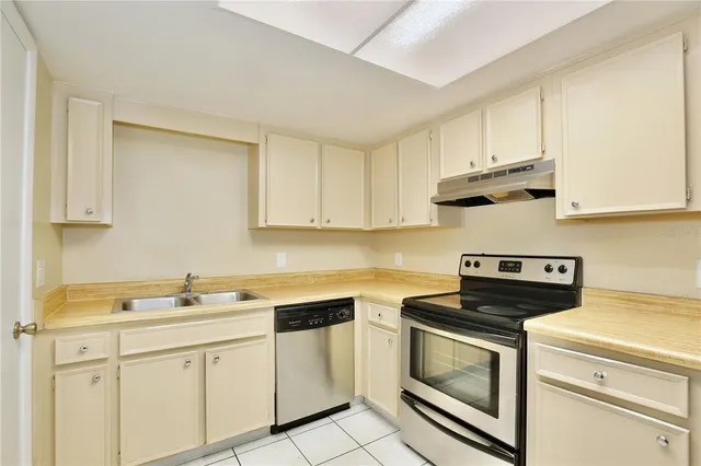 a kitchen with white cabinets stainless steel appliances and sink