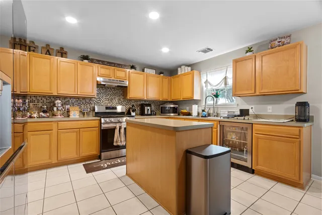 a kitchen with stainless steel appliances granite countertop a stove a sink and a refrigerator