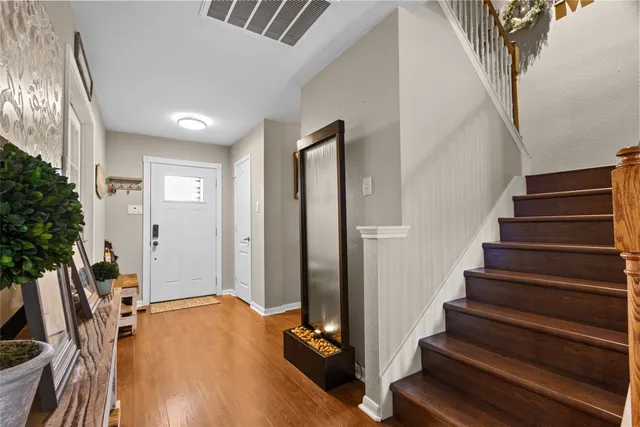 a view of a hallway with wooden floor and staircase