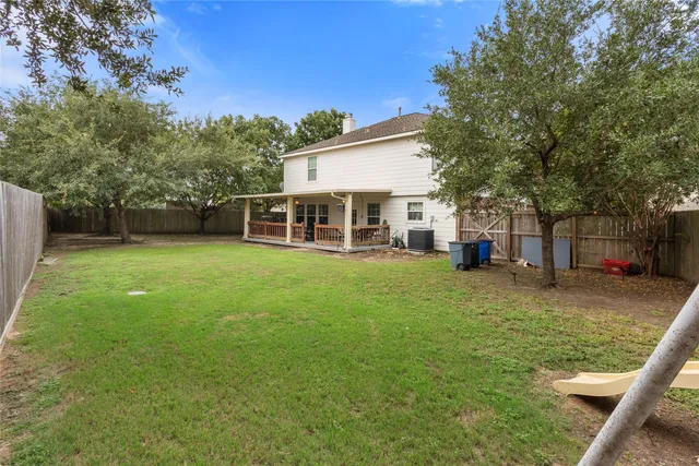 a view of a house with a backyard and a tree