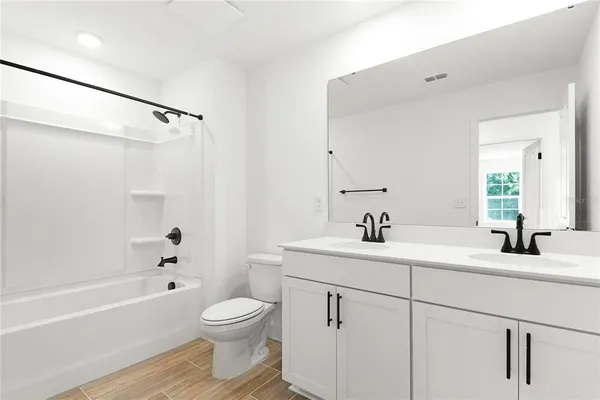 a bathroom with a bathtub shower sink vanity and toilet