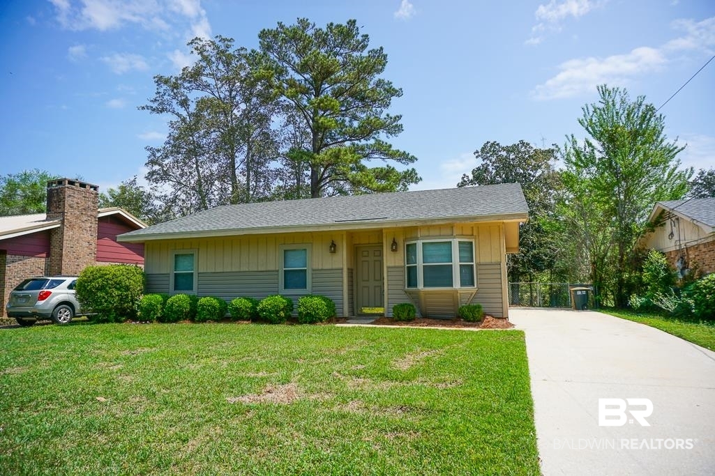 4377 Fathbrook Lane Mobile, AL 36693 - Photo 1 of 19 Ranch-style home with board and batten siding, a front lawn, concrete driveway, and roof with shingles