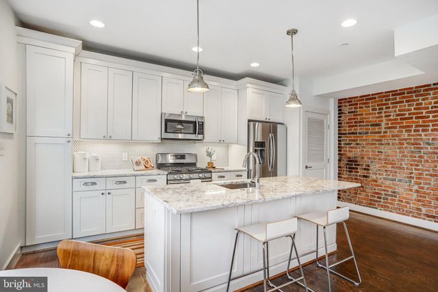 a kitchen with stainless steel appliances granite countertop a kitchen island a stove a cabinets and a refrigerator