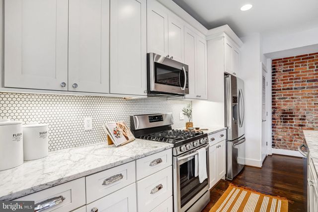 a kitchen with granite countertop a sink stainless steel appliances and cabinets