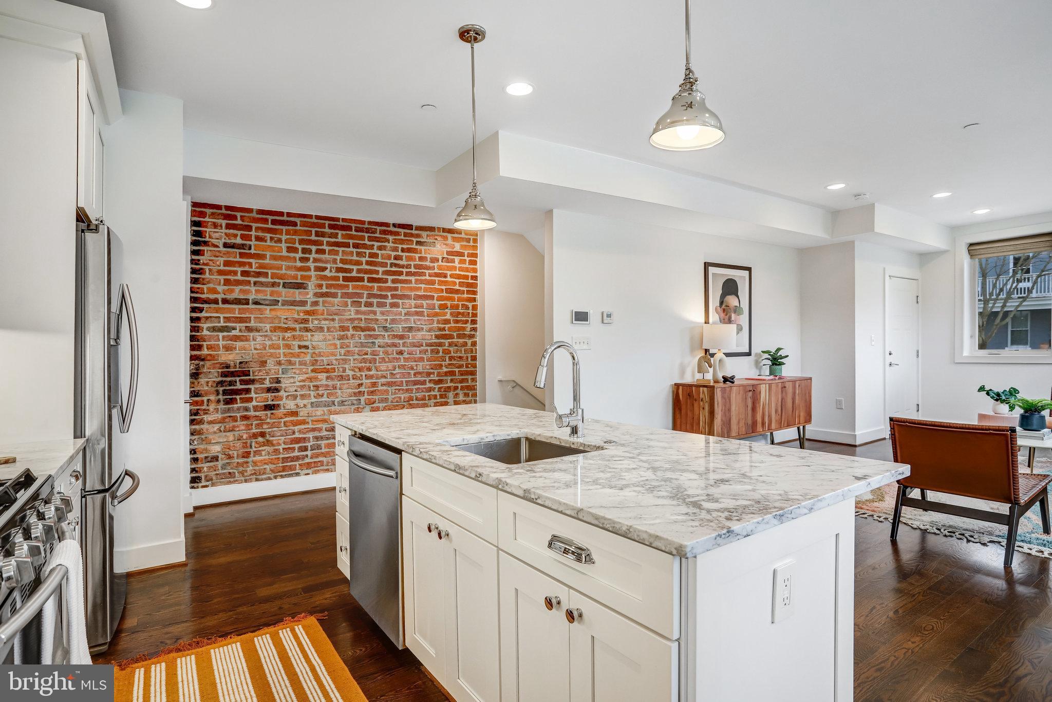 1200 Staples Street Northeast, Unit 1 Washington, DC 20002 - Photo 16 of 37 a kitchen with granite countertop kitchen island stainless steel appliances a sink and cabinets