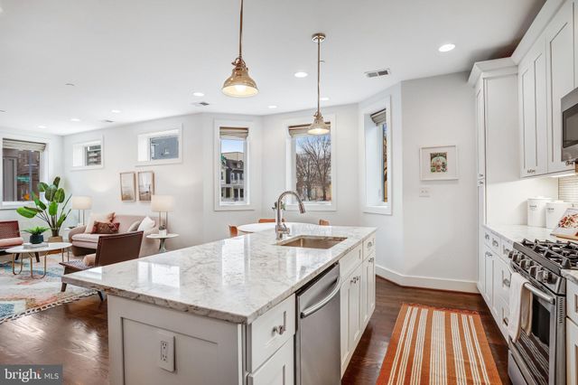 a kitchen with a sink stove and wooden floor