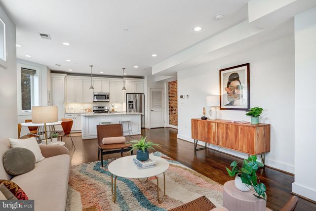 a living room with furniture kitchen view and a potted plant