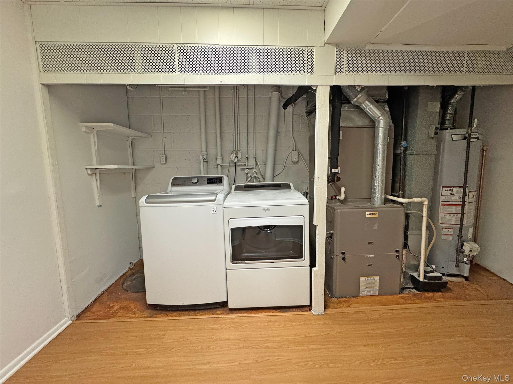 461 Pinebrook Boulevard New Rochelle, NY 10804 - Photo 24 of 32 Laundry area featuring water heater, wood finished floors, washer and dryer, and heating unit