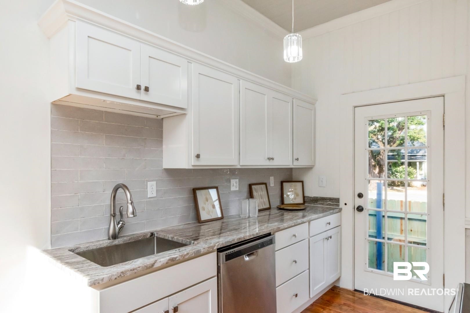 352 Marine Street Mobile, AL 36604 - Photo 7 of 20 Kitchen with stainless steel dishwasher, white cabinets, decorative backsplash, light stone countertops, and crown molding