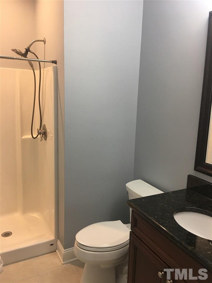 925 Pebblebrook Drive Raleigh, NC 27609 - Photo 19 of 23 a bathroom with a granite countertop toilet and a shower